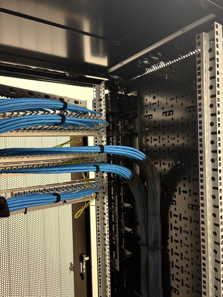 Blue Cat6 looms velcro-dressed into the rear of the patch panels in a new cabinet