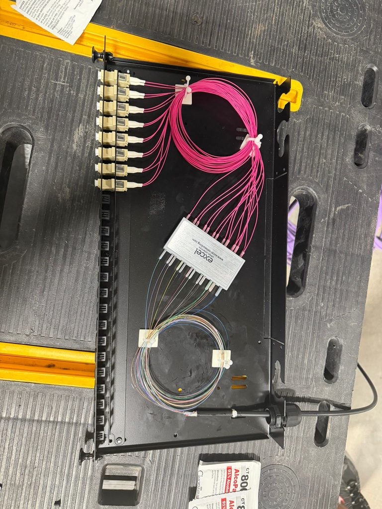 Fibre tray built up on the bench with OM4 pigtails coiled into an Excel splice module
