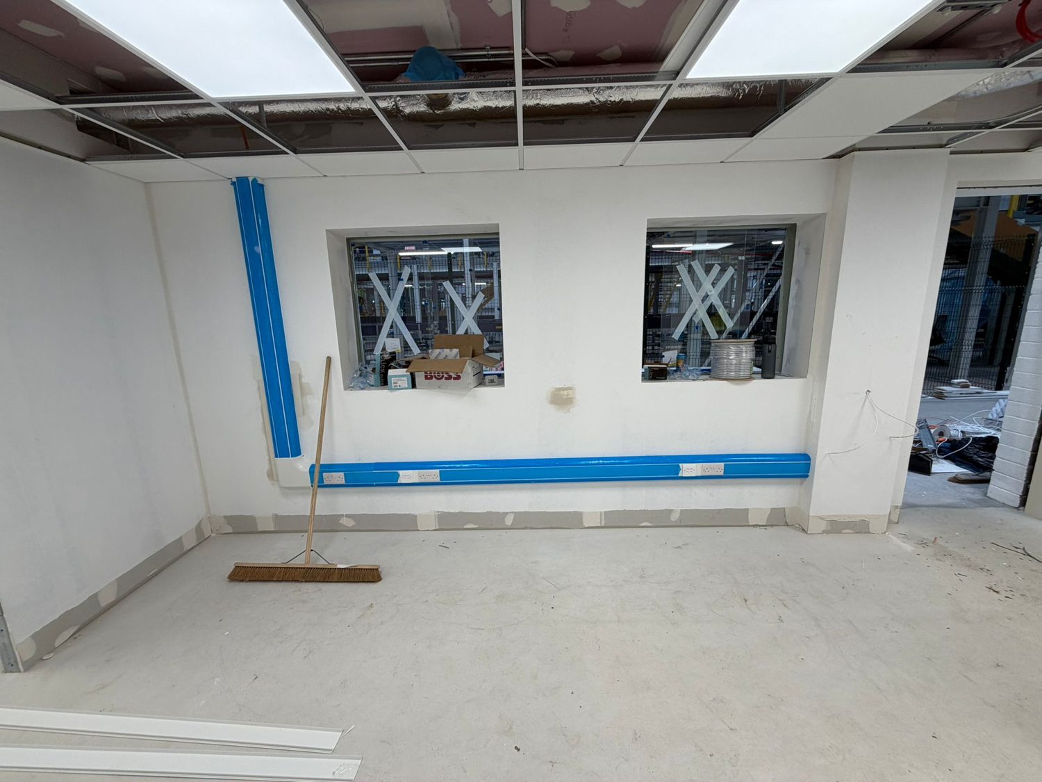 Completed install with wall-mounted displays and tidy trunking