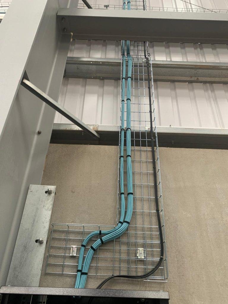 Vertical basket drop feeding cabling down to a comms cabinet