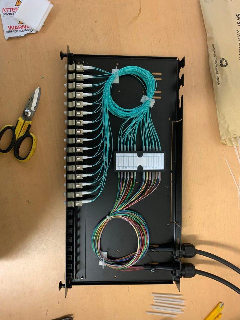 Fibre patch panel mid-build with OM3 pigtails routed and coiled for splicing